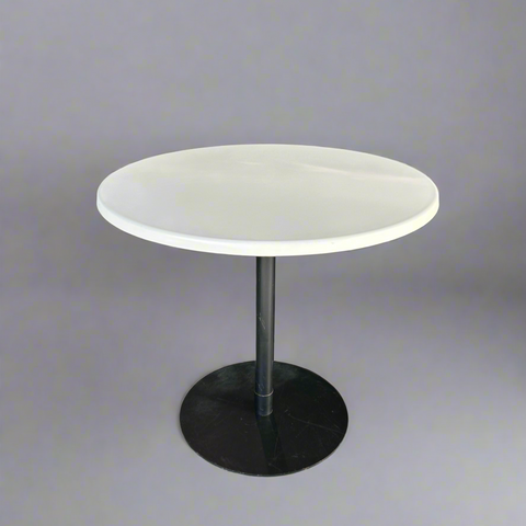 Round table with a white top and black base on a gray background