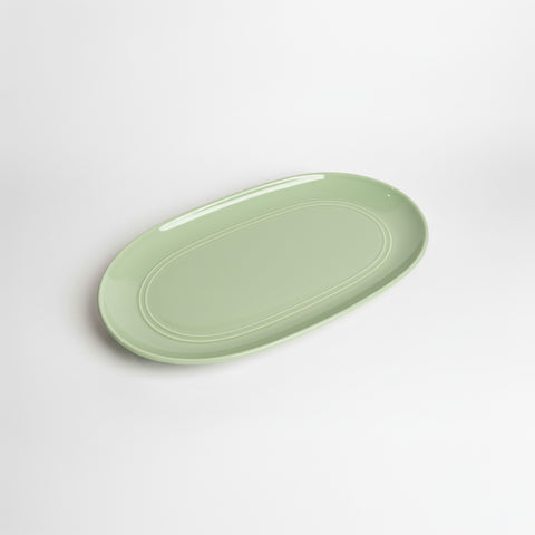Green ceramic platter on a white background