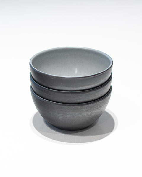 Stack of gray melamine bowls on a white background