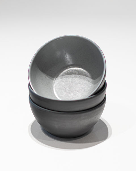 Stack of gray melamine bowls on a white background
